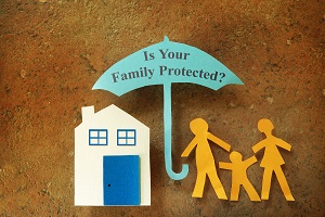 paper cutouts of home, a family and an umbrella with "is your family protected" written on it